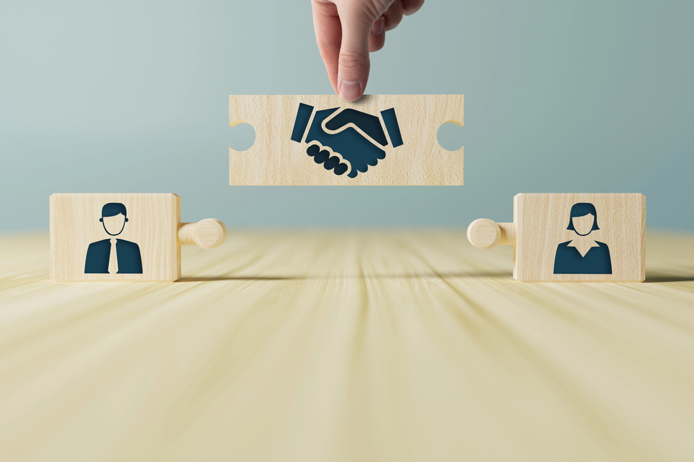 Mediator in gesprek met twee partijen aan tafel